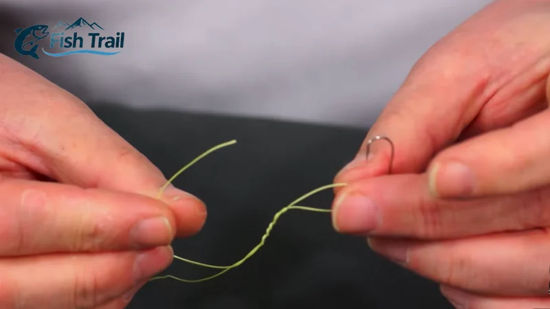 Preparing to pass the tag end through the loop after wrapping fishing line for a clinch knot