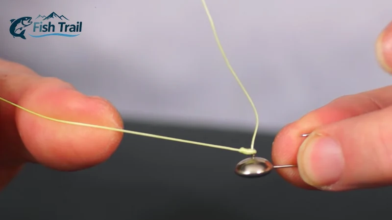 Pulling the fishing line to tighten a clinch knot against the eye of a mormyshka
